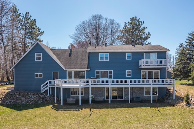 rear view of property featuring a lawn, a chimney, a balcony, and a deck