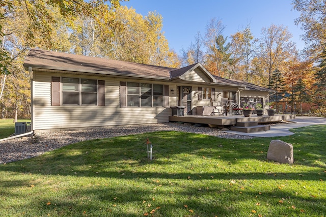 rear view of house featuring a lawn, central AC, and a wooden deck