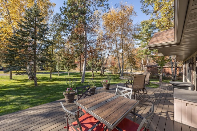 wooden terrace with a lawn and outdoor dining space