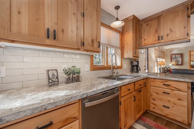 kitchen featuring a sink, light countertops, dark wood finished floors, tasteful backsplash, and stainless steel dishwasher