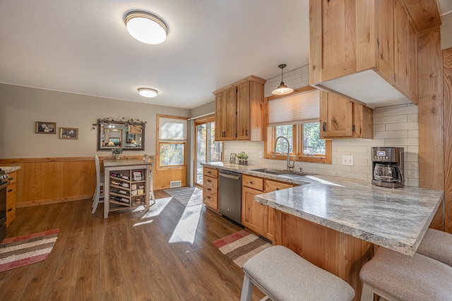 kitchen featuring a sink, dishwasher, light countertops, tasteful backsplash, and dark wood-type flooring