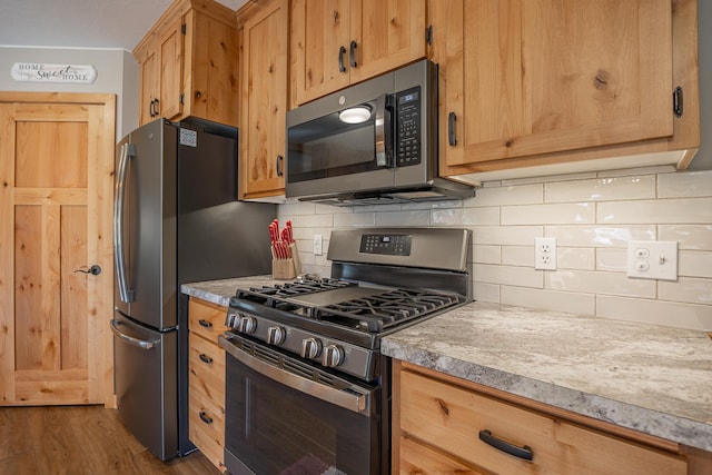 kitchen with light countertops, stainless steel appliances, and decorative backsplash