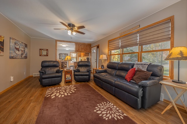 living area with baseboards, ceiling fan, visible vents, and wood finished floors