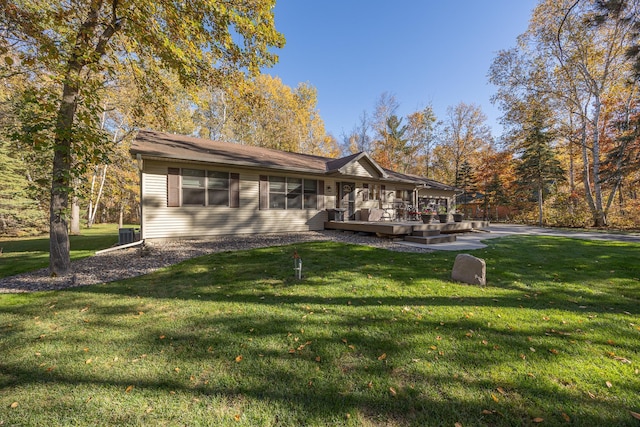 back of property with a yard and central AC