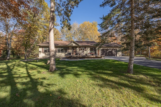 ranch-style home with a garage, a front lawn, and aphalt driveway