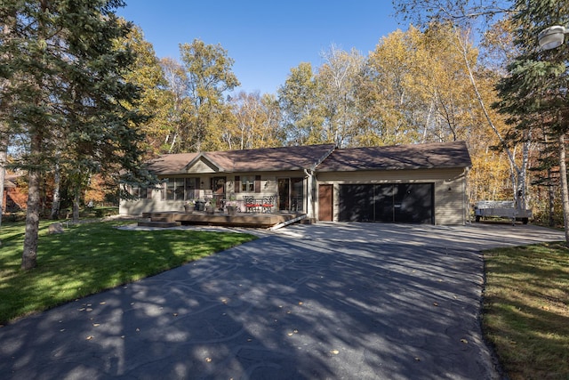ranch-style home with an attached garage, a porch, driveway, and a front yard
