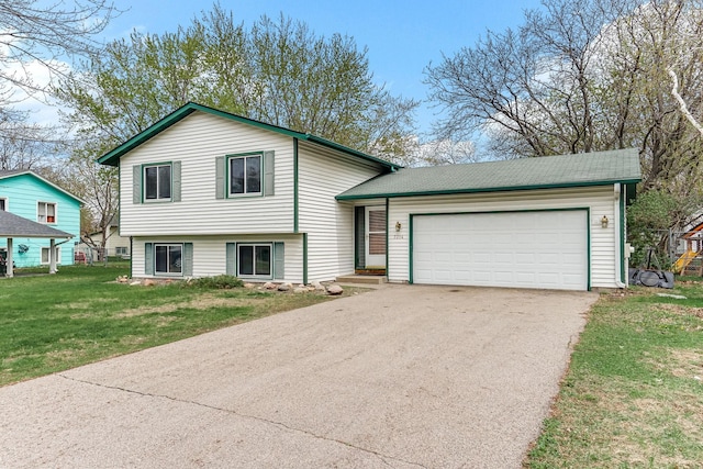 split level home featuring a garage, a front lawn, and driveway