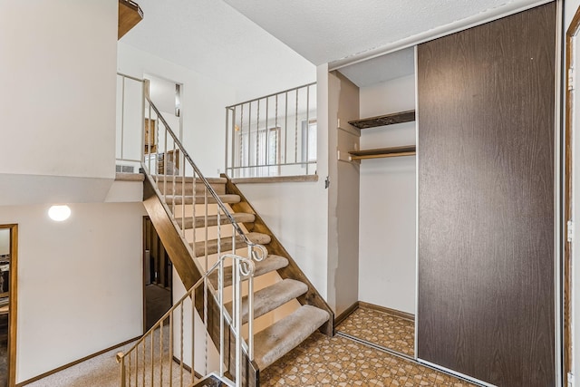 stairway with baseboards and tile patterned floors