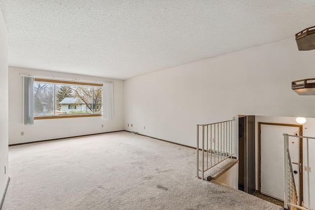 spare room with carpet floors and a textured ceiling