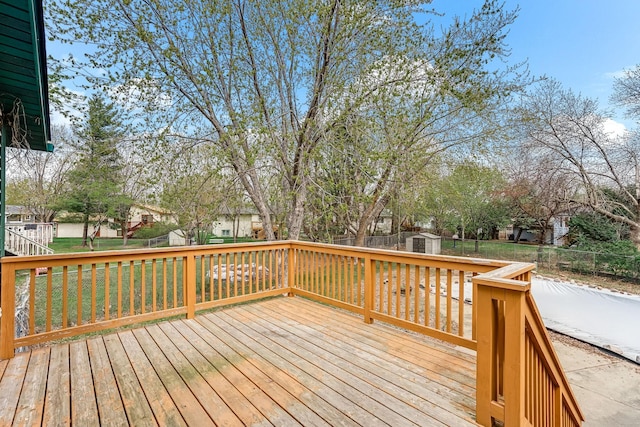 wooden terrace with a fenced backyard, an outbuilding, a shed, and a residential view
