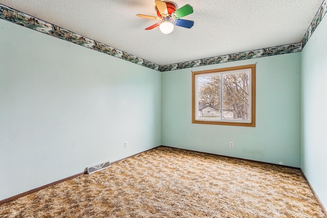 unfurnished room featuring visible vents, a textured ceiling, carpet floors, and ceiling fan