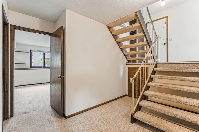 staircase with baseboards and carpet flooring
