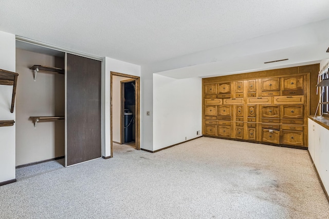unfurnished bedroom featuring a closet, carpet flooring, baseboards, and a textured ceiling