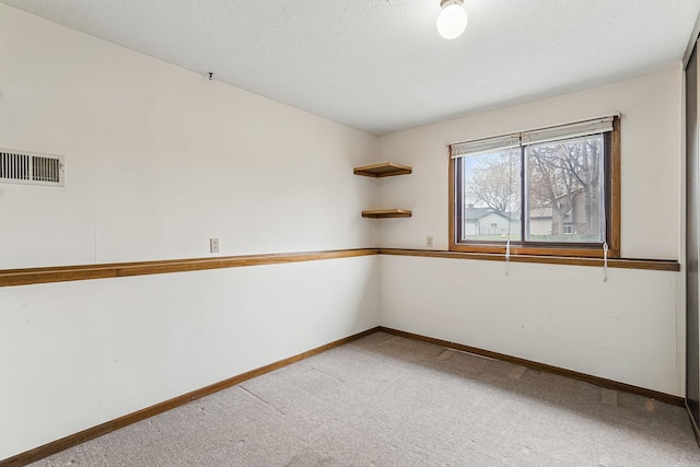 empty room with carpet flooring, baseboards, and visible vents