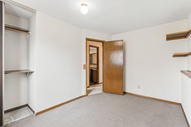unfurnished bedroom with carpet flooring, baseboards, and a closet