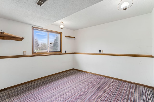 empty room featuring baseboards, carpet flooring, a textured ceiling, and visible vents