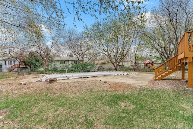 view of yard with fence, a playground, and stairway
