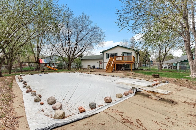 view of yard with stairway, fence, a wooden deck, and a playground