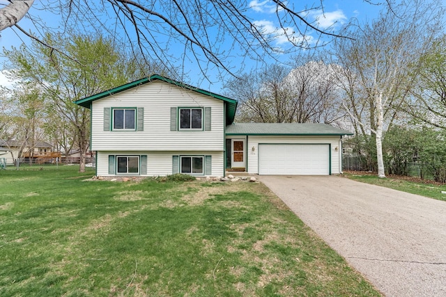 tri-level home with a garage, a front lawn, aphalt driveway, and fence