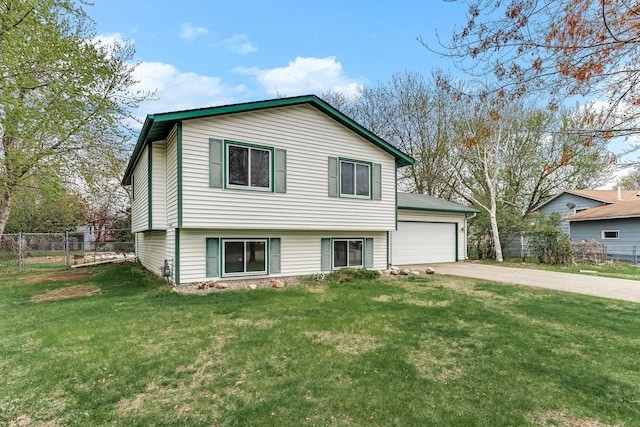 split level home with concrete driveway, fence, a front lawn, and a garage