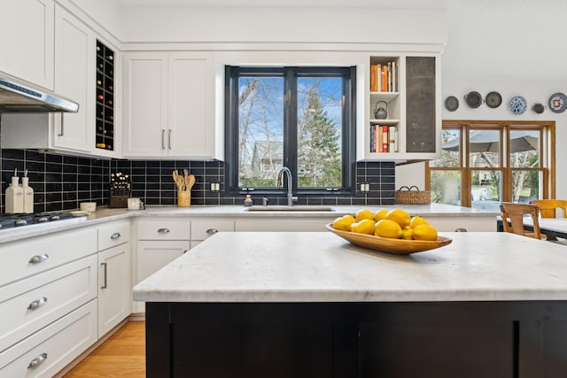 3412 Williamsburg Pkwy, Woodbury, MN 55129 - kitchen with a sink, white cabinetry, stainless steel gas cooktop, and tasteful backsplash