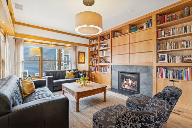 3412 Williamsburg Pkwy, Woodbury, MN 55129 - living area with crown molding, visible vents, wood finished floors, a fireplace, and built in shelves