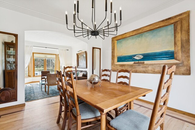 3412 Williamsburg Pkwy, Woodbury, MN 55129 - dining room featuring arched walkways, ornamental molding, baseboards, and wood finished floors