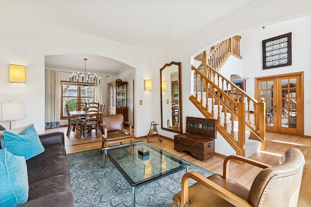 3412 Williamsburg Pkwy, Woodbury, MN 55129 - living area with an inviting chandelier, arched walkways, french doors, wood finished floors, and ornamental molding