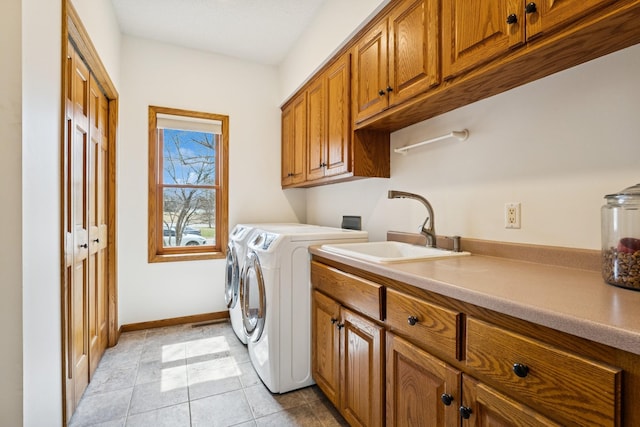 3412 Williamsburg Pkwy, Woodbury, MN 55129 - clothes washing area featuring cabinet space, washing machine and clothes dryer, a sink, baseboards, and light tile patterned floors