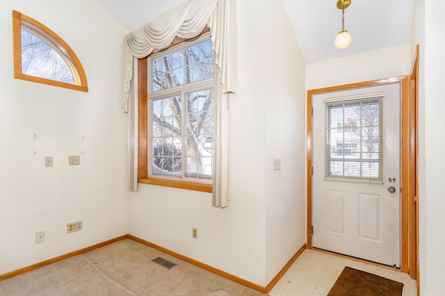 entryway featuring baseboards, vaulted ceiling, and visible vents