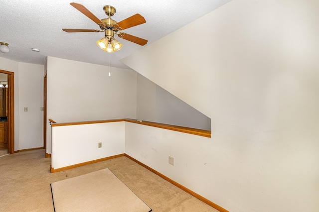 spare room featuring baseboards, ceiling fan, and light colored carpet