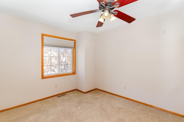 unfurnished room featuring visible vents, a ceiling fan, baseboards, and light colored carpet