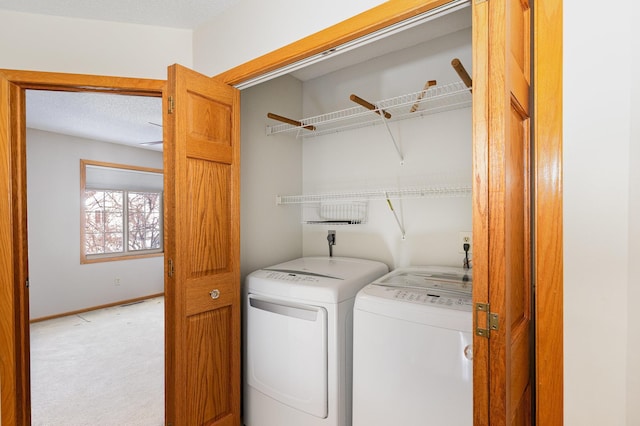 washroom featuring laundry area, baseboards, independent washer and dryer, and light colored carpet