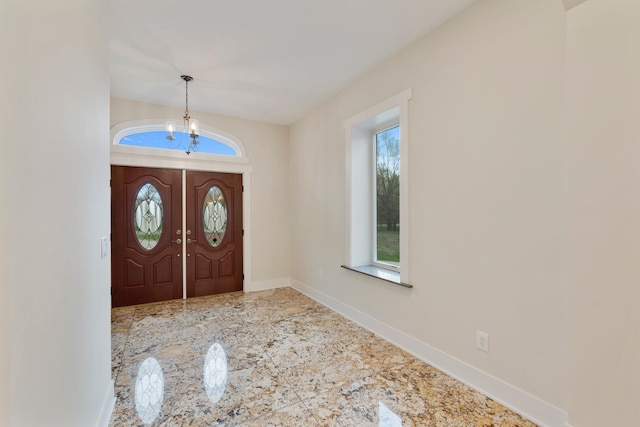 entrance foyer with baseboards and a notable chandelier