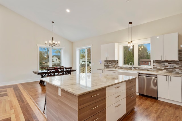 kitchen with a sink, tasteful backsplash, lofted ceiling, and dishwasher