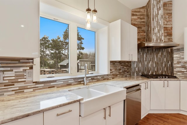 kitchen featuring white cabinets, light stone countertops, a sink, stainless steel appliances, and backsplash