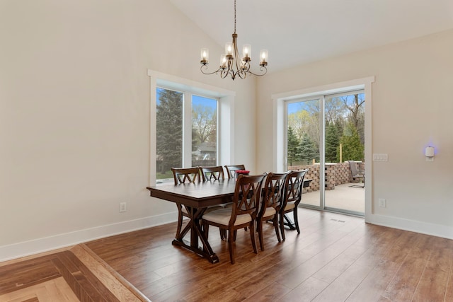 dining room featuring baseboards, a chandelier, and wood finished floors
