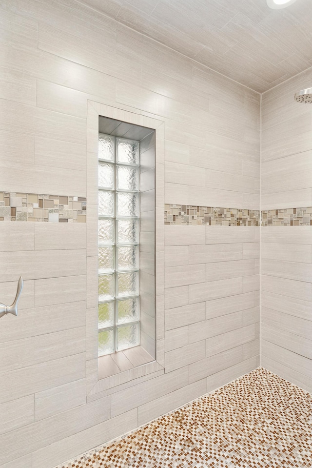full bath featuring tiled shower and a wealth of natural light