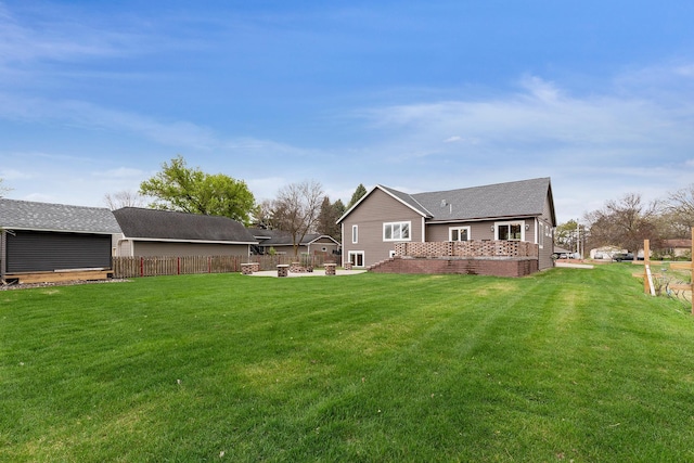 rear view of house with fence and a yard