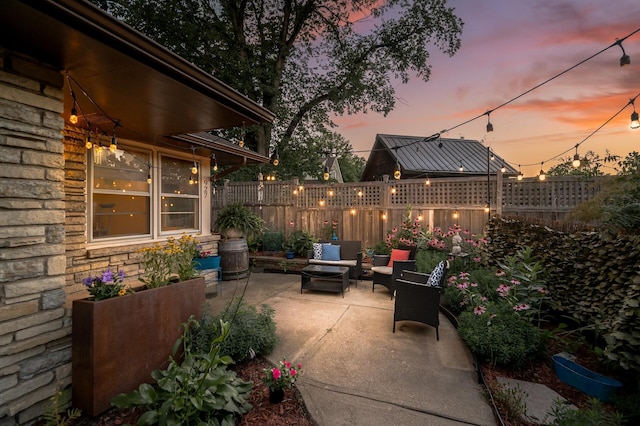 patio terrace at dusk with a fenced backyard and an outdoor hangout area