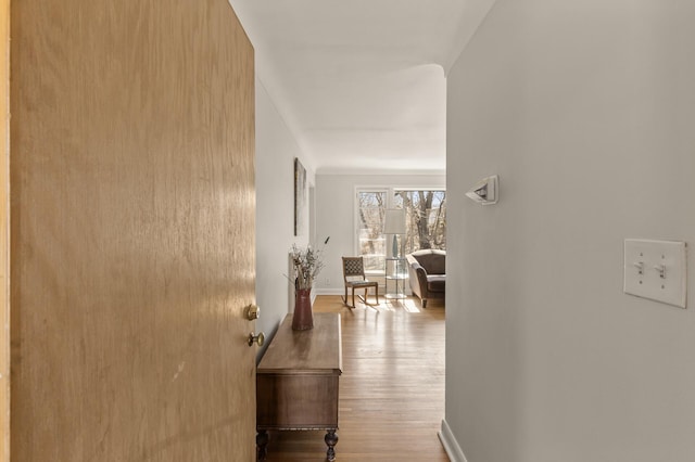 corridor featuring baseboards and wood finished floors