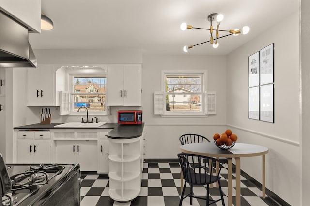 kitchen featuring a sink, dark countertops, black gas range oven, and tile patterned floors