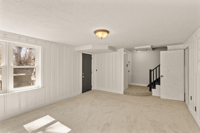empty room featuring light carpet and stairway