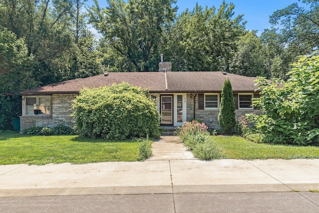 view of front of house with a chimney, stone siding, and a front yard
