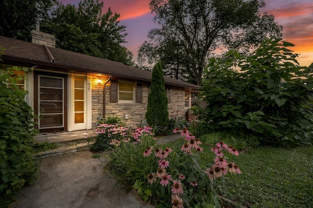 exterior space with a chimney and stone siding