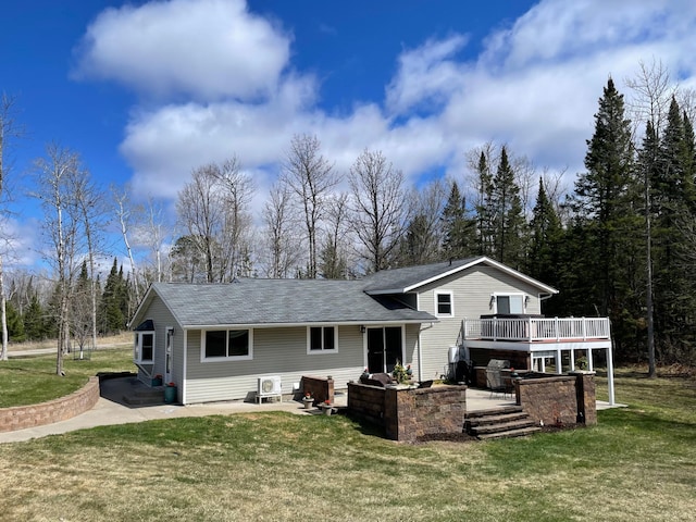 back of house with a yard, a deck, a patio area, and roof with shingles