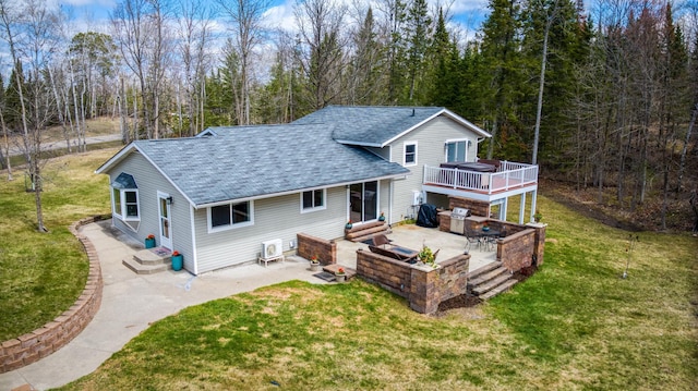 back of house with a yard, a patio area, a shingled roof, and a deck
