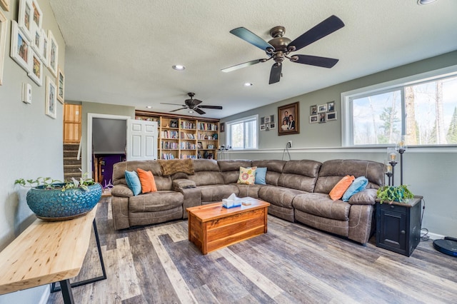living area featuring a textured ceiling, a ceiling fan, recessed lighting, and wood finished floors