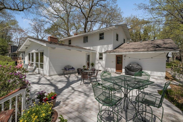 956 10th Ave SE, Forest Lake, MN 55025 - back of property with outdoor dining space, a chimney, and a wooden deck