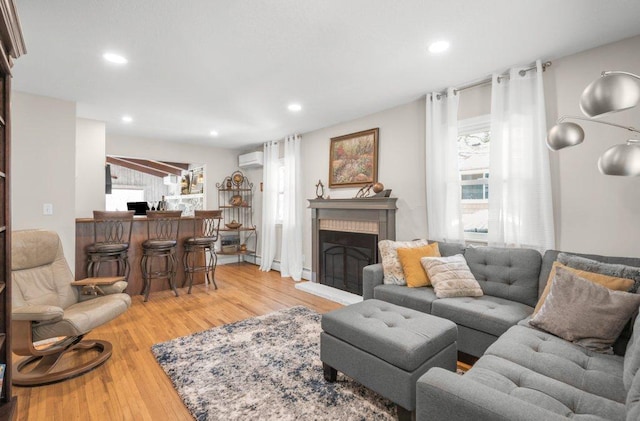 956 10th Ave SE, Forest Lake, MN 55025 - living area featuring a wall mounted air conditioner, light wood finished floors, a fireplace, and recessed lighting